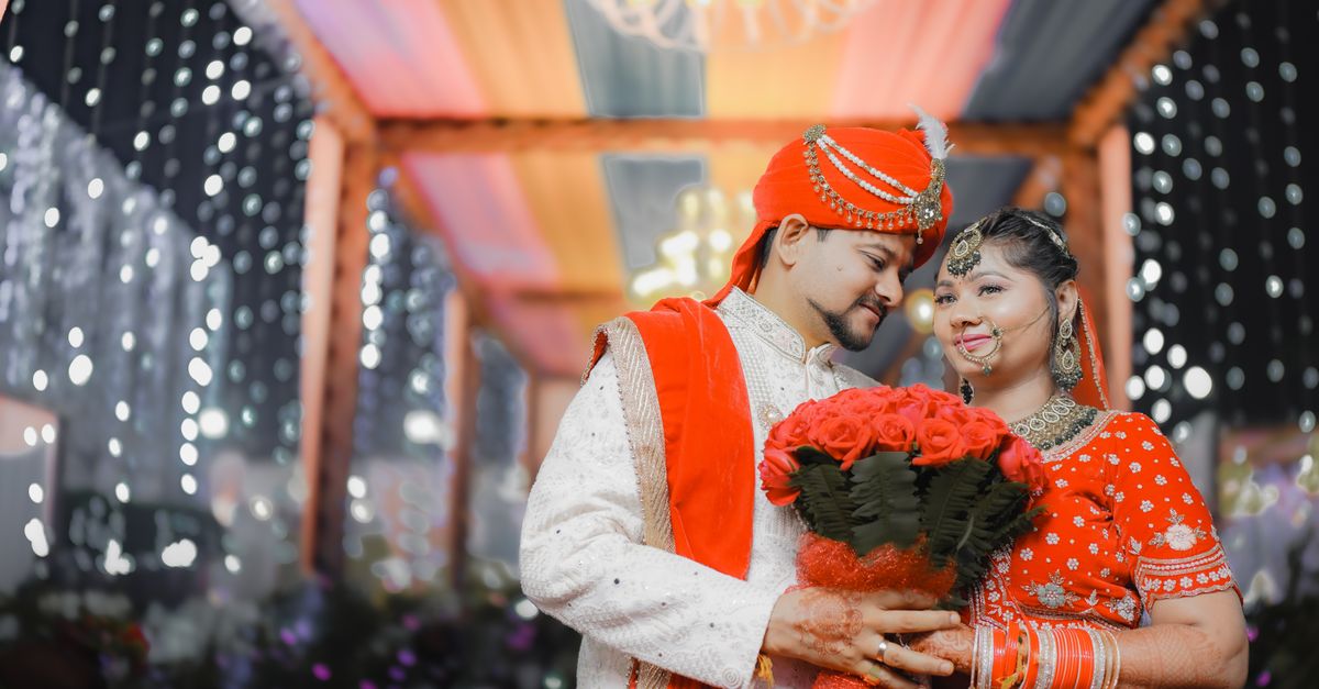 A couple being married beneath a decorated mandap at a Hindu wedding ceremony
