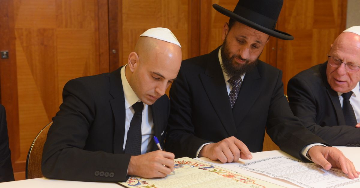 A decorated ketubah being signed before the ceremony